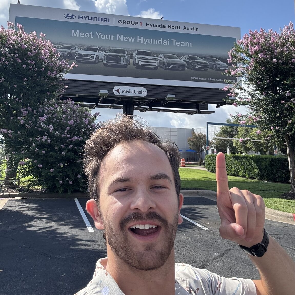 Justin Mays with a Group 1 Automotive campaign billboard